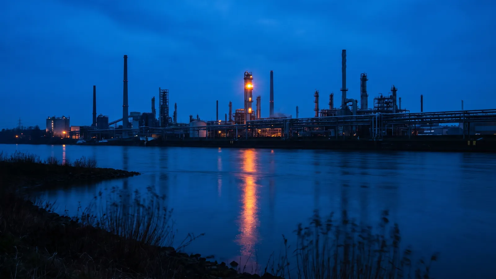 Industriesilhouette des Chemparks am Rhein zur blauen Stunde mit bernsteinfarbenen Lichtern